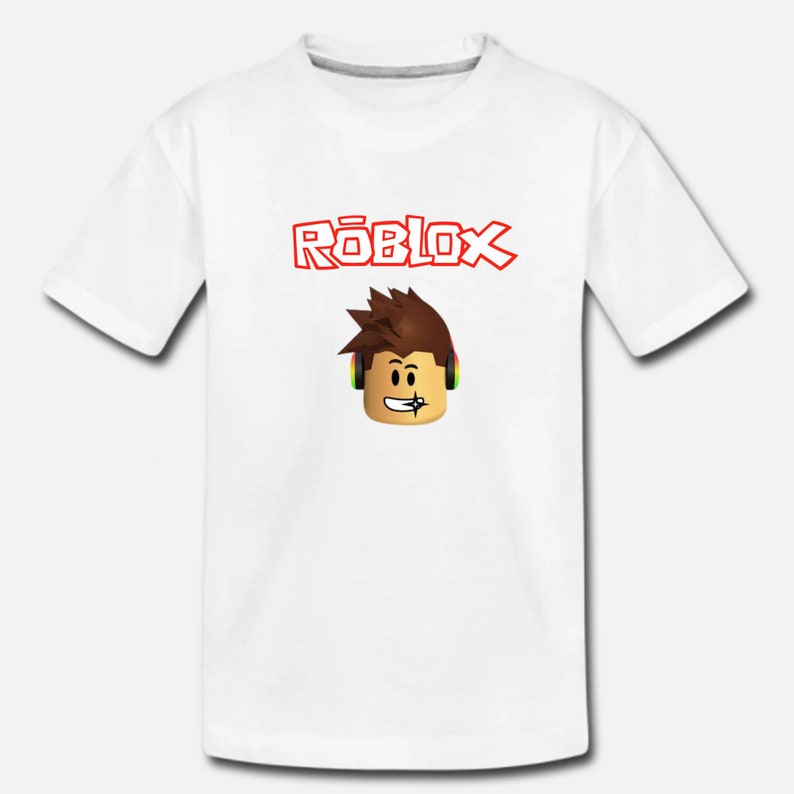 Puede incluir: Camiseta blanca con un logotipo rojo "ROBLOX" y un personaje de dibujos animados con auriculares.