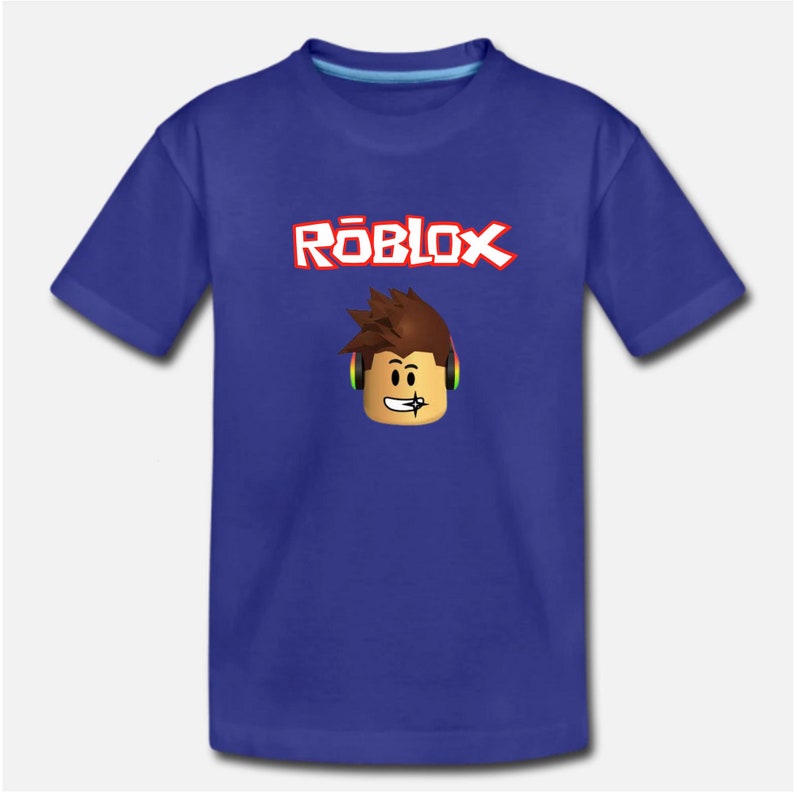 Puede incluir: Una camiseta azul real con un logotipo "ROBLOX" blanco y rojo y un personaje de dibujos animados con auriculares.