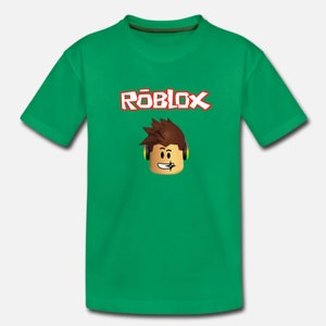 Puede incluir: Camiseta verde con un logotipo de Roblox y un personaje de dibujos animados con auriculares. El logotipo es en rojo y blanco con la palabra "Roblox" en una fuente estilizada.