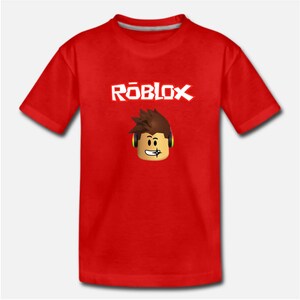 Puede incluir: Camiseta roja con un logotipo "ROBLOX" blanco y un personaje de dibujos animados con auriculares.