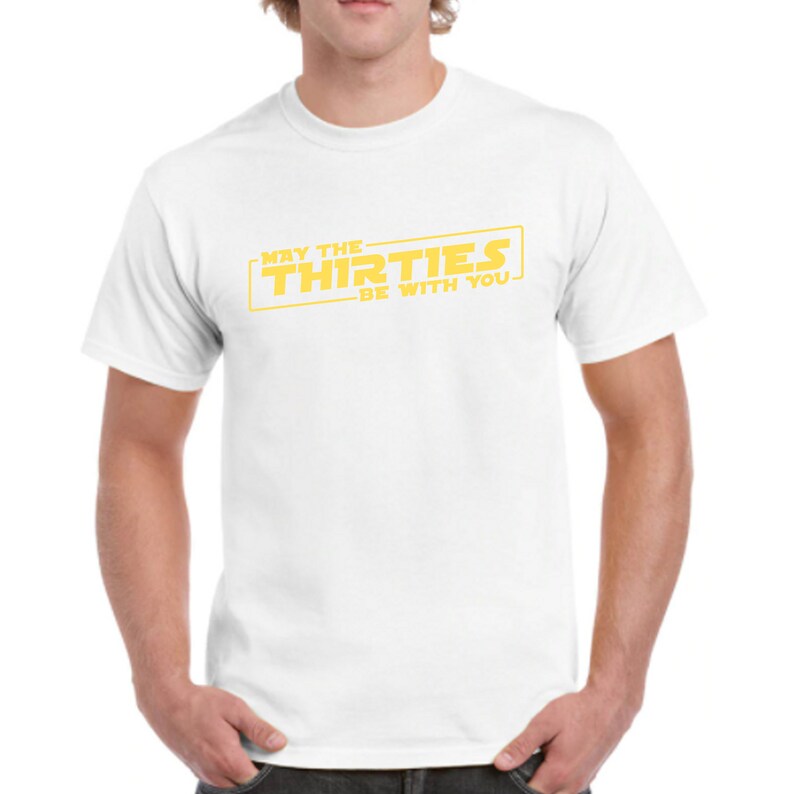 May include: White t-shirt with a yellow graphic that says "May the Thirties Be With You" in a Star Wars-inspired font.