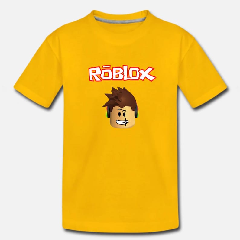 Puede incluir: Camiseta amarilla con un logotipo de Roblox y un personaje de dibujos animados de Roblox con auriculares.
