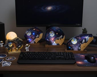 May include: A collection of galaxy-themed decorative lights and accessories on a wooden desk. The lights feature a celestial design with planets and stars. Includes a moon-shaped lamp, astronaut figurines, and a galaxy-themed mousepad.