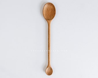 May include: A wooden spoon with a rounded bowl and a long, slender handle. The spoon is made of light brown wood and has a natural finish.
