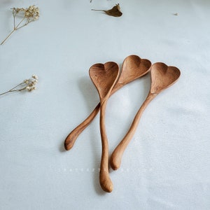 Custom wooden heart spoon displayed as a unique anniversary gift for couples.
