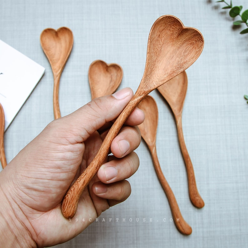 Rustic wooden heart spoon with engraving, perfect for wedding anniversary gifts.