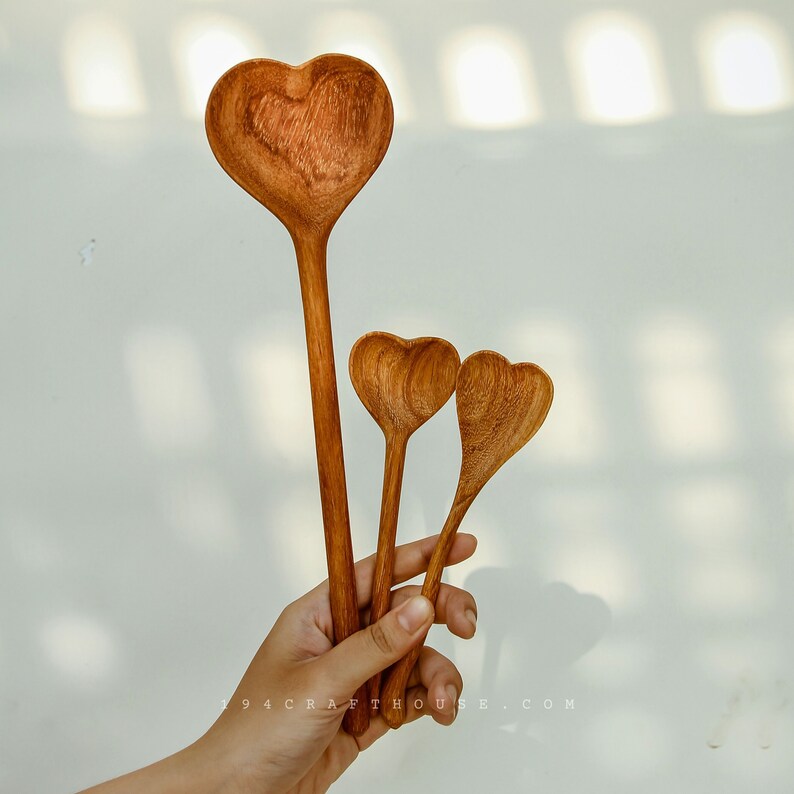 Custom engraved wooden heart spoon displayed with wedding place settings.
