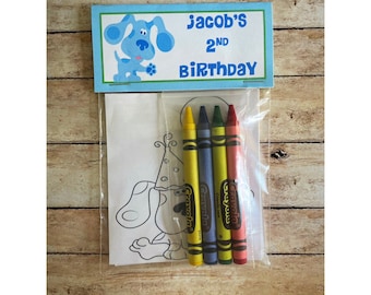 May include: A clear plastic bag containing a coloring page and four crayons. The coloring page features a cartoon dog. Above the bag is a blue and white card that reads "Jacob's 2nd Birthday" with a cartoon dog illustration.