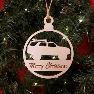 May include: A wooden Christmas ornament shaped like a circle with a cutout of a car and the words "Merry Christmas".
