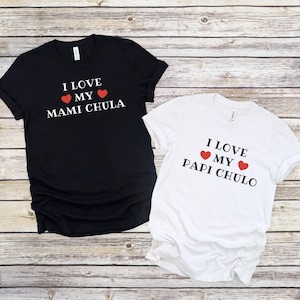 May include: Two black and white t-shirts with red hearts and the text "I love my Mami Chula" and "I love my Papi Chulo" printed on them.
