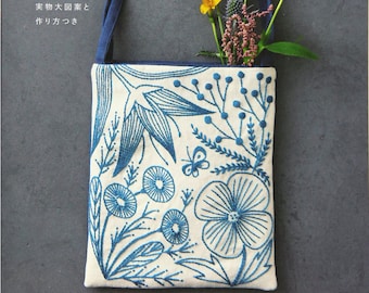 May include: A book cover with the title "Botanical Embroidery" in Japanese and English. The cover features a blue tote bag with a floral embroidery design and a bouquet of flowers.