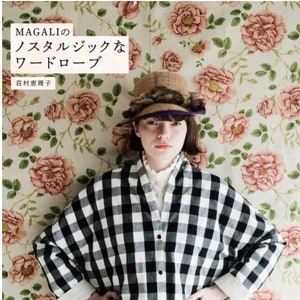 May include: A book cover featuring a woman wearing a black and white checkered shirt with a straw hat. The background is a floral pattern. The title of the book is "MAGALI's nostalgic wardrobe" in Japanese.