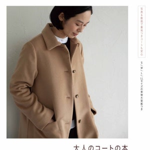 May include: A tan coat with a button closure and pockets. The text "大人のコートの本" is printed in black on a white background below the image. The text "前川友子" is printed in black on a white background below the text "大人のコートの本". The text "Heart Warming Life Series" is printed in black on a white background below the text "前川友子". The text "日本ヴォーグ社" is printed in black on a white background below the text "Heart Warming Life Series".