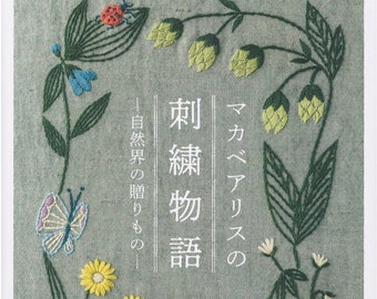May include: Embroidered floral designs on a green fabric background. The text "刺繡 物語" (meaning "Embroidered Stories") is in the center of the image. The text "マカベリアスの" (meaning "Macaberias") is on the right side of the image. The text "自然の贈りもの" (meaning "Gifts of Nature") is on the left side of the image.