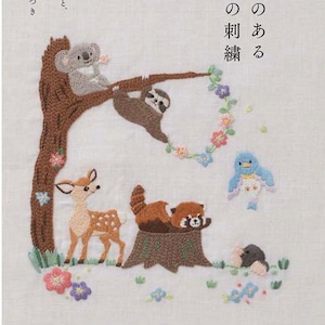 以下が含まれることがあります： 「物語のある動物」というタイトルの日本語の書籍の表紙。表紙には、木の枝にぶら下がっているナマケモノ、枝に座っているコアラ、草むらに立っている鹿、木の切り株に座っているレッサーパンダ、飛んでいる青い鳥、木の切り株の後ろから顔を出しているモグラの刺繍イラストが描かれている。イラストは刺繍の花で囲まれている。