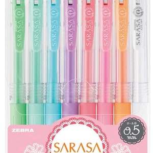 May include: A set of eight Zebra Sarasa Clip gel pens in pastel colors. The pens are 0.5 mm and have a clear barrel with a colored ink cartridge. The packaging features a pink background with a white lace design and the text "Sarasa Clip" in Japanese and English. The text "Milk Color" is also featured on the packaging.