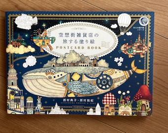 以下が含まれることがあります： 空想街雑貨店の旅する塗り絵 POSTCARD BOOKと書かれた長方形のポストカードブック。表紙は濃い青色で、機械的なディテールを持つ大きなクジラ、浮かぶ島々、飛行船、キノコが描かれています。下部には西村典子・西村祐紀 NISHIMURA NORIKO & YUKIと記載されています。