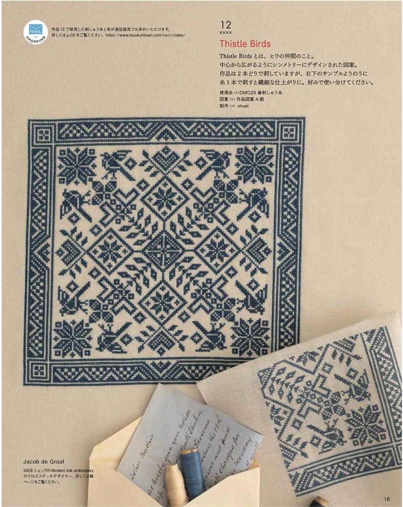 May include: A page from a cross-stitch pattern book featuring a detailed blue and white floral design. The design includes birds and geometric shapes. The text "Thistle Birds" is visible, along with Japanese text and a small envelope with a handwritten note.