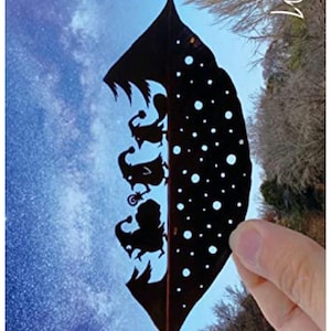 May include: A black silhouette of a group of birds on a brown feather with a starry sky background. The feather is held by a hand. The word "Vita" is written in white on the right side of the image.