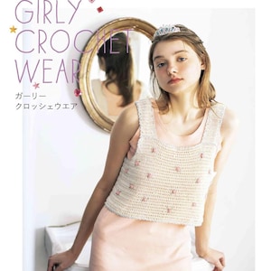 May include: A beige sleeveless crochet top featuring a square neckline and small pink floral embellishments. The text on the image reads applemints GIRLY CROCHET WEAR and Japanese characters. The top is worn over a light pink garment.