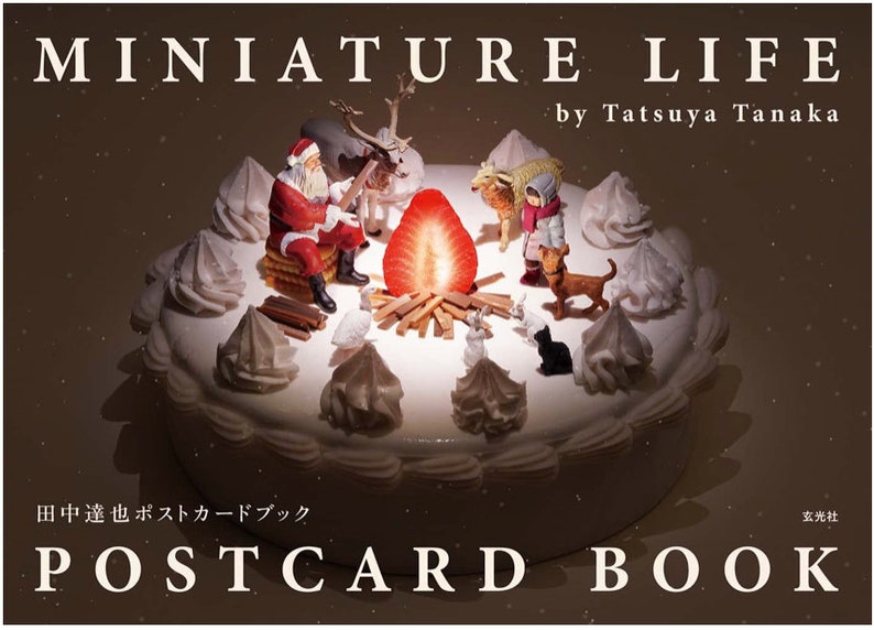 Puede incluir: Una escena navide&ntilde;a en miniatura con Santa Claus, renos y otras figuras sobre un pastel blanco con una fresa roja en la parte superior. La escena est&aacute; iluminada por una peque&ntilde;a fogata. El texto "MINIATURE LIFE by Tatsuya Tanaka" est&aacute; en la parte superior de la imagen. El texto "田中達也ポストカードブック 玄光社 POSTCARD BOOK" est&aacute; en la parte inferior de la imagen.