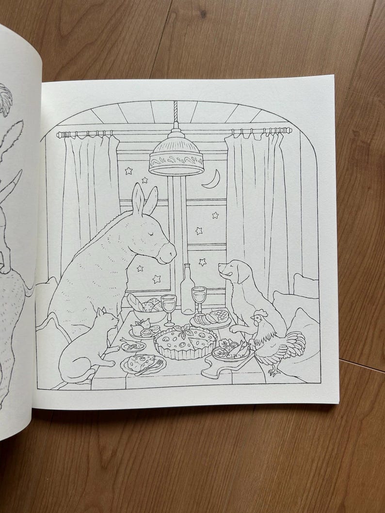 Op de afbeelding: Een zwart-wit kleurboekpagina met een illustratie van een ezel, een hond, een kat en een kip die rond een tafel zitten. Op de tafel staan een grote taart, wijnglazen en eten. De sc&egrave;ne speelt zich af voor een raam met gordijnen en sterren.