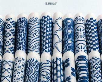 May include: A book cover titled "クロスステッチで楽しむ 和の模様" featuring a collection of white fabric rolls embroidered with various blue geometric cross-stitch patterns. The text includes "市松、千鳥、格子、花菱など可愛くて美しい伝統文様 76" and the author name "遠藤佐絵子" with "河出書房新社" at the bottom.