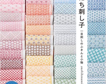 May include: A book with the title "まいにち刺し子 - 一目刺しのふきんと小物 sashikonami"  and a collection of colorful fabric squares with different embroidery patterns. The book includes instructions for making these patterns.