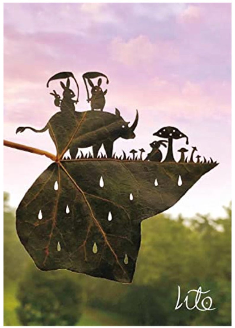 May include: A leaf with a rhino, two rabbits, and mushrooms cut out of it. The leaf is green and has raindrops cut out of it. The background is a pink and purple sky.