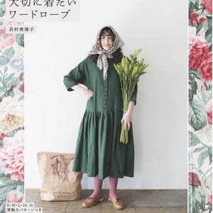 May include: A woman in a green dress and headscarf holds a bundle of wheat. The dress has buttons down the front and a gathered skirt. The background features floral patterns and Japanese text. A paper bag is on the floor.