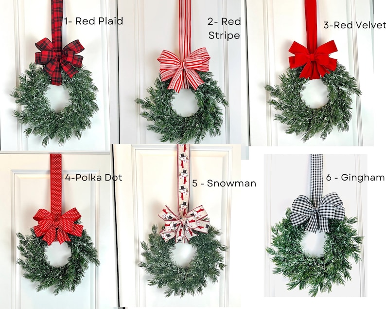 May include: Six decorative wreaths with green foliage and various red ribbon designs. The ribbons include red plaid, red stripe, red velvet, polka dot, snowman, and gingham patterns. Each wreath is hung on a white door.