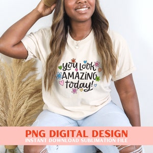 May include: A white t-shirt with the text "You look amazing today!" in black script with colourful flowers and hearts surrounding the text.