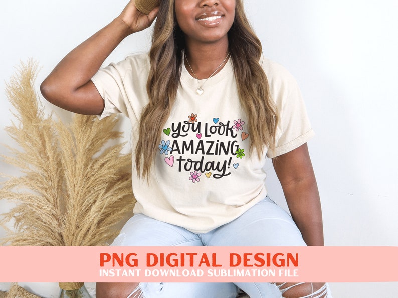 May include: A white t-shirt with the text "You look amazing today!" in black script with colourful flowers and hearts surrounding the text.