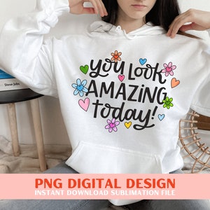 May include: White hoodie with a graphic design that says "You Look Amazing Today!" with colourful flowers and hearts.