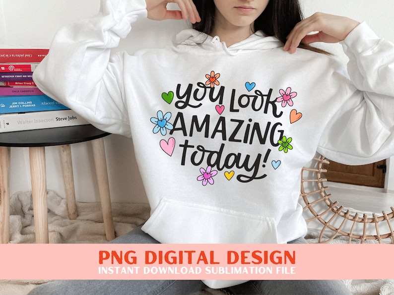 May include: White hoodie with a graphic design that says "You Look Amazing Today!" with colourful flowers and hearts.