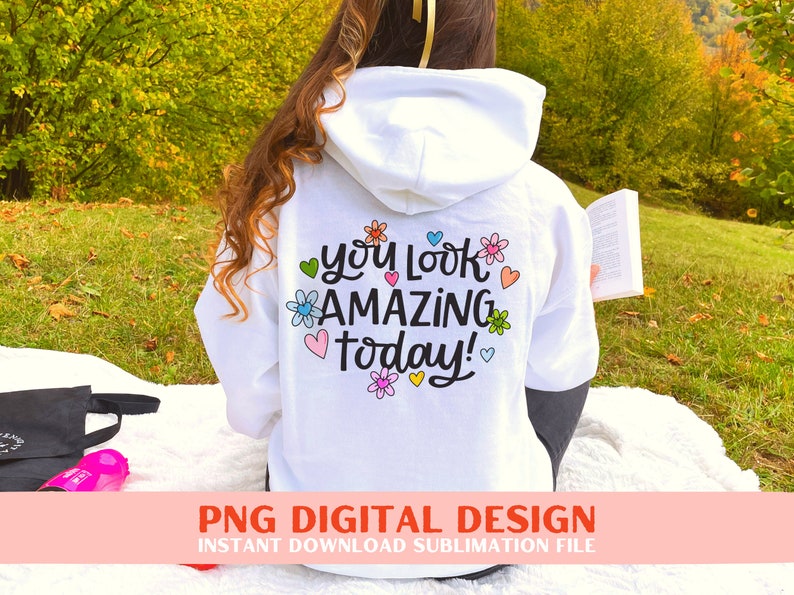 May include: White hoodie with a colourful floral design and the text "You look amazing today!" printed on the back.