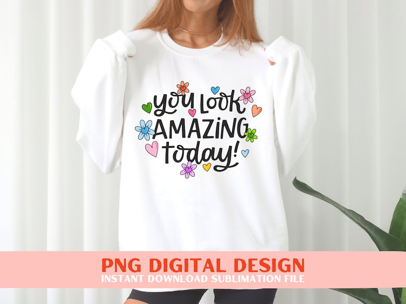 May include: White sweatshirt with the text "you look amazing today!" in black script with colourful flowers and hearts surrounding the text.