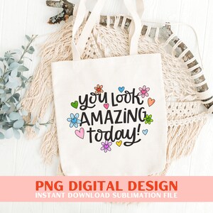 May include: A white tote bag featuring the text "you look amazing today!" in black lettering, surrounded by colourful flowers and hearts.