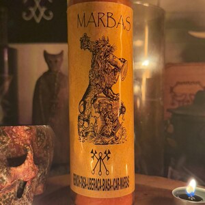 K&ouml;nnte beinhalten: Eine gelbe und orangefarbene Kerze mit einem Schwarzwei&szlig;bild eines L&ouml;wen, der eine Trompete h&auml;lt. Die Kerze tr&auml;gt den Aufdruck "MARBAS" und den Text "RENOVIL-TASA-UBERACA-BIASA-ICAR-MARBAS" am Boden.