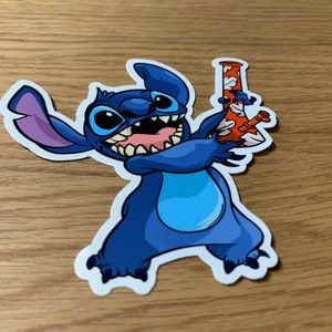 May include: A blue cartoon character with three fingers on each hand holding a red and white glass bong. The character has a wide grin and large eyes.