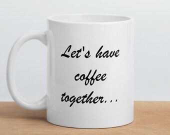 May include: White ceramic coffee mug with black text that reads "Let's have coffee together..."