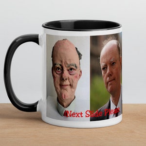 May include: White ceramic mug with a black rim and handle. The mug features a photo of two men, one with a red tie and the other with a blue tie. The text "Next Slide Please" is printed in red at the bottom of the mug.