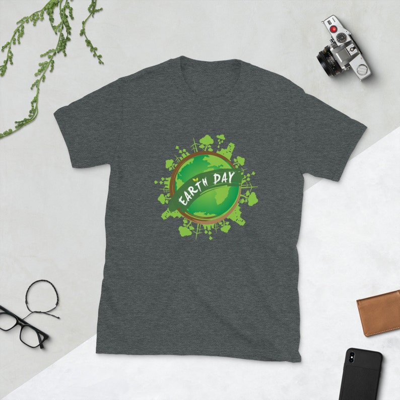 May include: A dark heather grey t-shirt with a green graphic of the Earth surrounded by trees and buildings. The text "EARTH DAY" is written on the graphic.