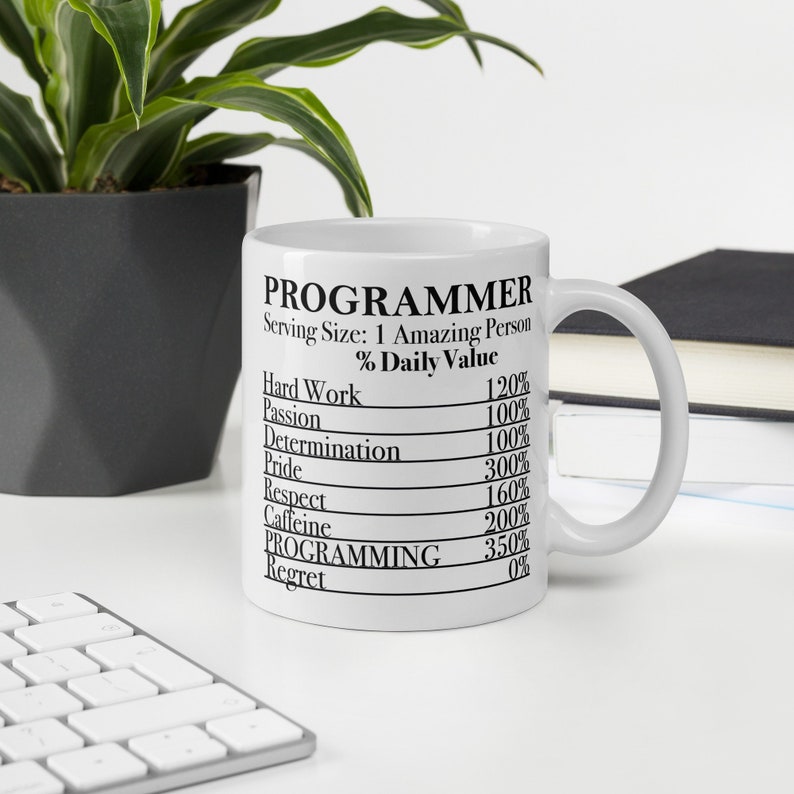 Peut inclure: Une tasse en c&eacute;ramique blanche avec un graphique noir qui indique "PROGRAMMEUR" et liste le pourcentage de la valeur quotidienne de travail acharn&eacute;, de passion, de d&eacute;termination, de fiert&eacute;, de respect, de caf&eacute;ine, de programmation et de regret.