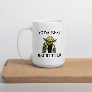 Pu&ograve; includere: Tazza in ceramica bianca con un personaggio verde di Yoda e il testo "YODA BEST RECRUITER".
