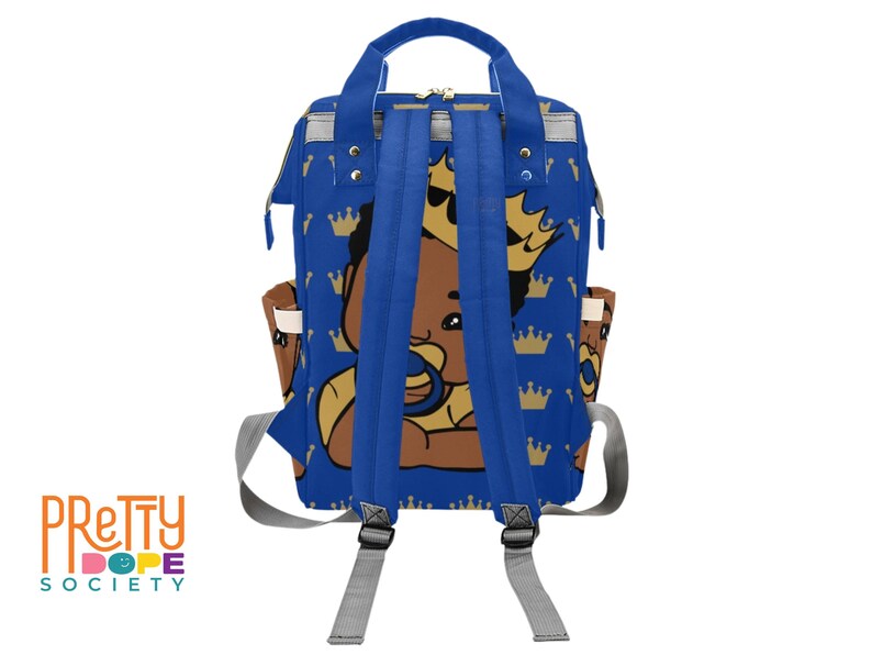 Puede incluir: Mochila azul con un beb&eacute; de dibujos animados con corona y chupete. La mochila tiene un patr&oacute;n repetido de coronas doradas sobre un fondo azul. Tiene correas azules, correas grises para los hombros y bolsillos laterales.