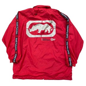 May include: Red windbreaker jacket with a white rhino logo and the text "Ecko Function" on the front and sleeves.