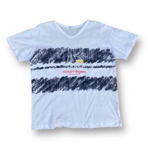 K&ouml;nnte beinhalten: Wei&szlig;es T-Shirt mit kurzen &Auml;rmeln und einem schwarz-wei&szlig;en Grafikdruck. Der Druck zeigt eine stilisierte Sonne und den Text "courr&egrave;ges sport futur".