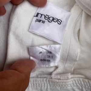 May include: White cotton t-shirt with a white tag that says "Im&egrave;ges Paris" and a white tag that says "100% DA I C-OS-168"