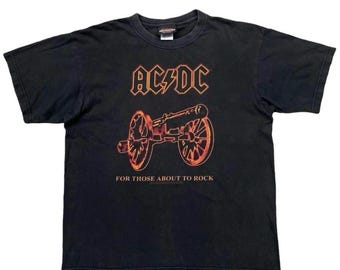 Camiseta vintage dos anos 90 da banda AC/DC "For Those About To Rock We Salute You!" Tamanho G. Estampa grande nas costas com o nome da banda. Camiseta vintage da banda. Tamanho G.
